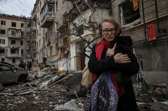 A woman leaves a residential complex heavily damaged during a Russian missile attack on Kharkiv in Jan. 2024 / Reuters