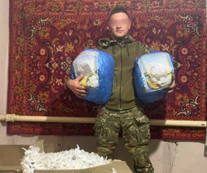A soldier holds a kit of warm items for frontline troops
